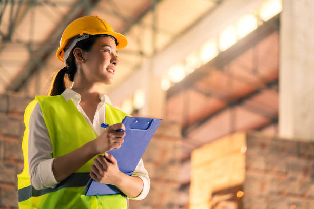 Latin American supervisor giving instructions to a warehouse worker to move boxes with a forklift