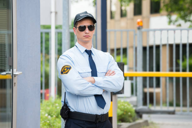 Confident security guard making stop gesture outside building