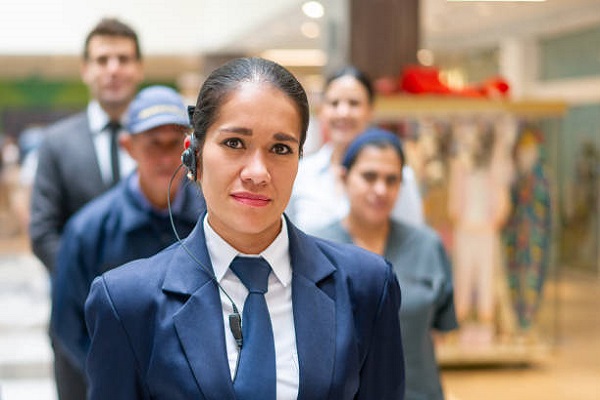 Portrait of a Latin American Security guard with a group of workers at a shopping mall – staff concepts