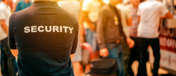 Confident security guard making stop gesture outside building